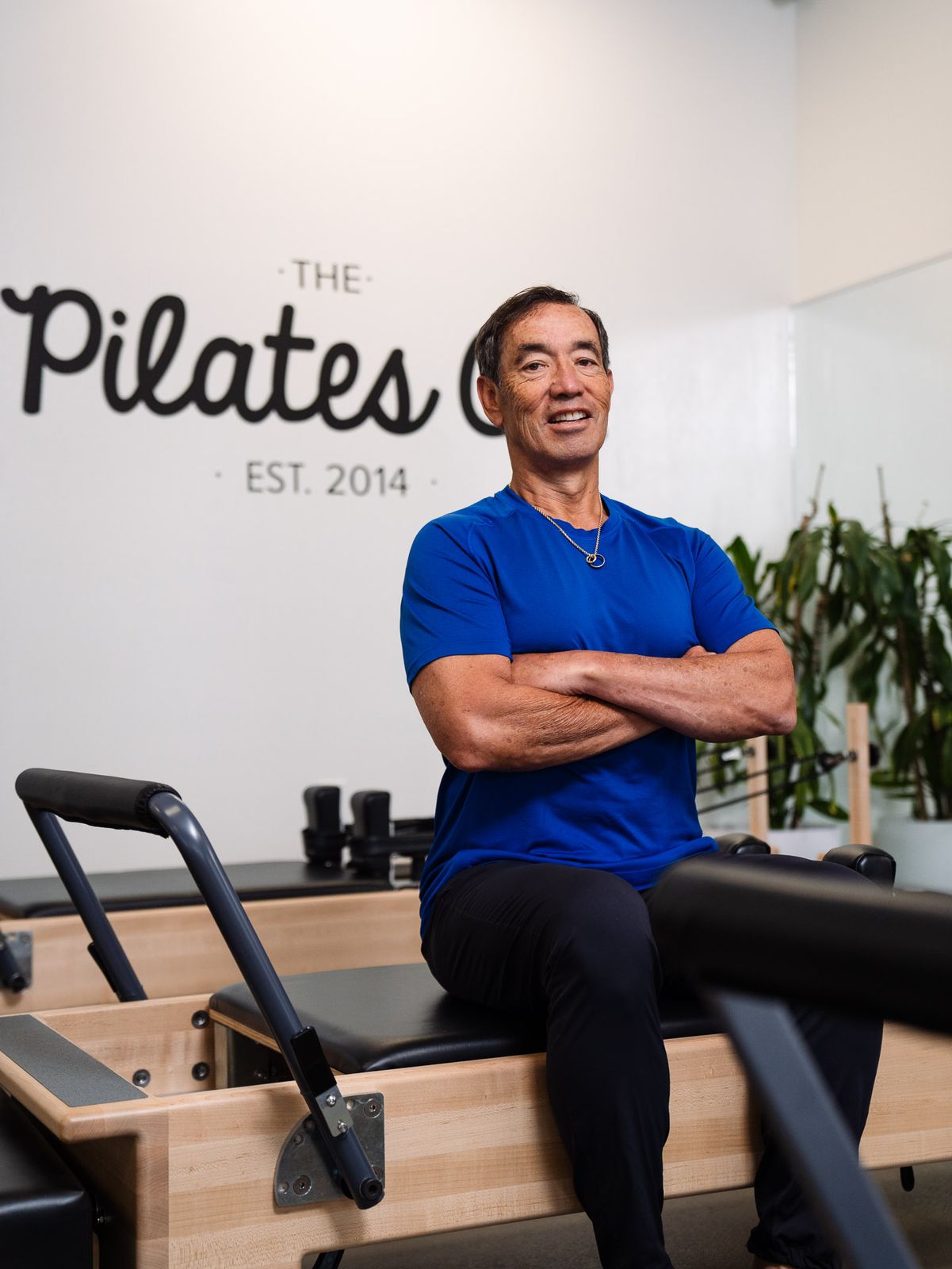 Dr. Jerry Hizon with arms crossed at a Pilates studio