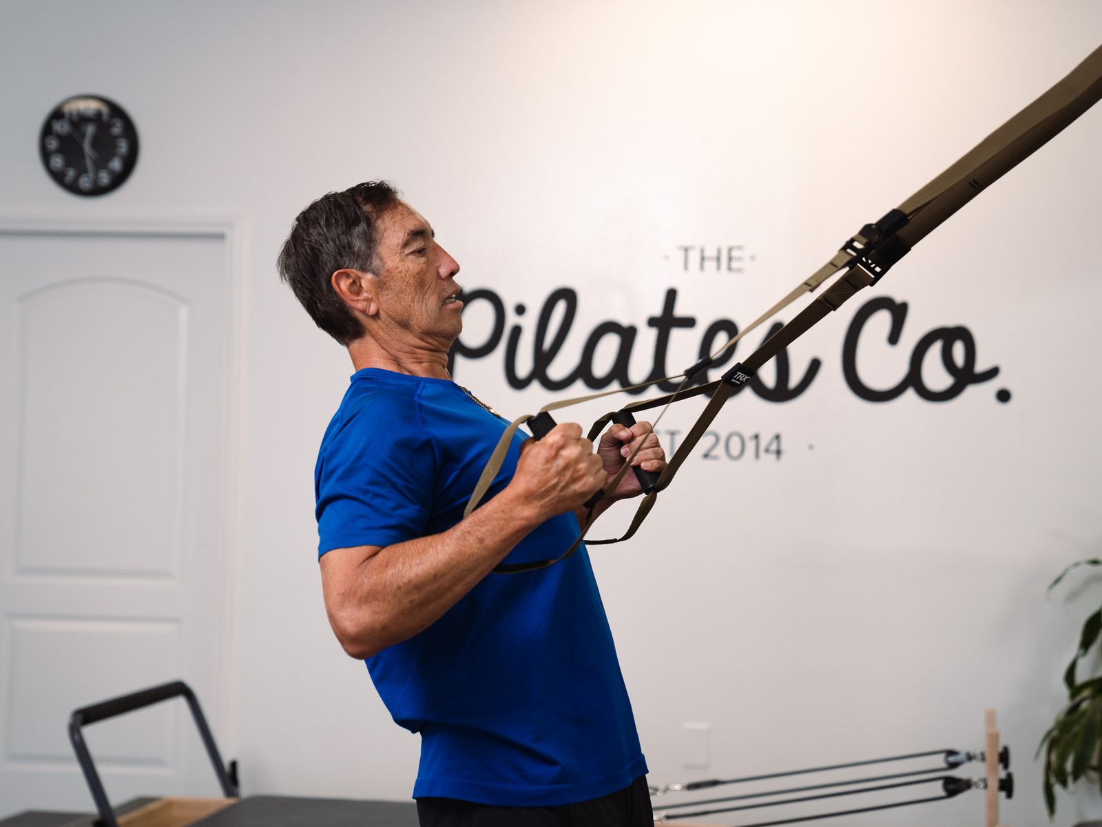 Dr. Jerry Hizon training on a suspension strap at a Pilates studio